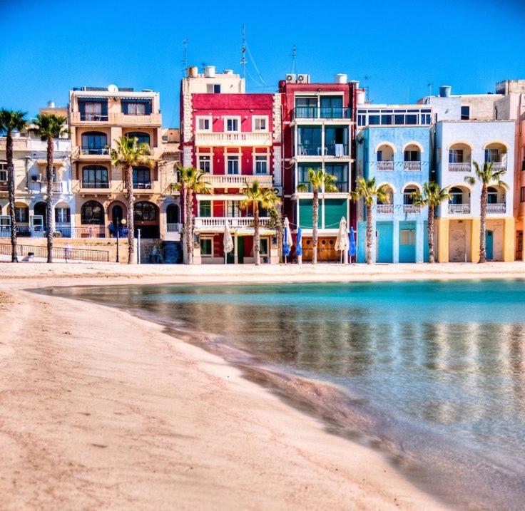 a group of buildings on a beach next to the water at Angolina Apartments 130 in Birżebbuġa