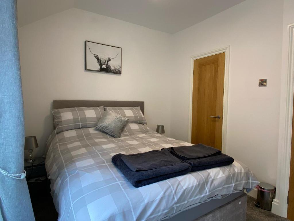 um quarto com uma cama com uma toalha azul em Hidden Gem Cottage, Driffield em Great Driffield