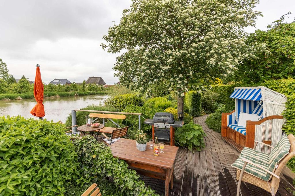 d'une terrasse avec des chaises et une table à côté d'une rivière. dans l'établissement Auszeit Hamburg-Altes Land, à Jork