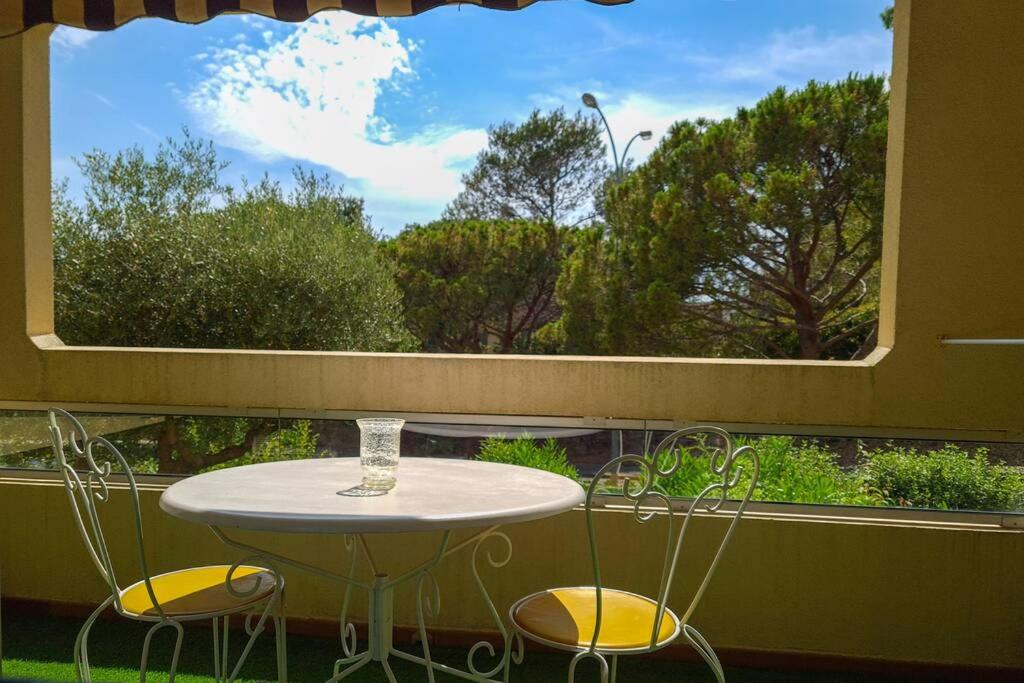 une table et deux chaises devant une fenêtre dans l'établissement Renovated apartment, air-conditioned 5min from sea, à Saint-Raphaël