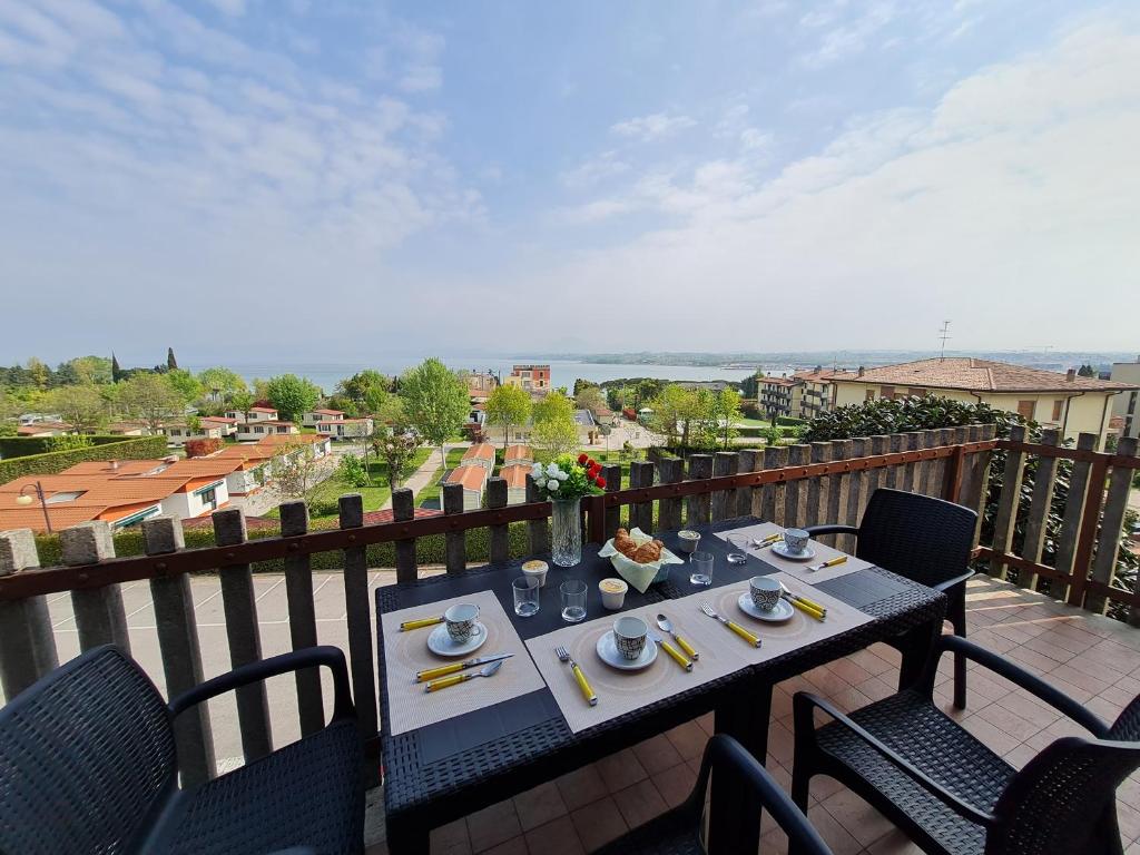 stół i krzesła na balkonie z widokiem w obiekcie Panorama Apartment Peschiera w mieście Peschiera del Garda
