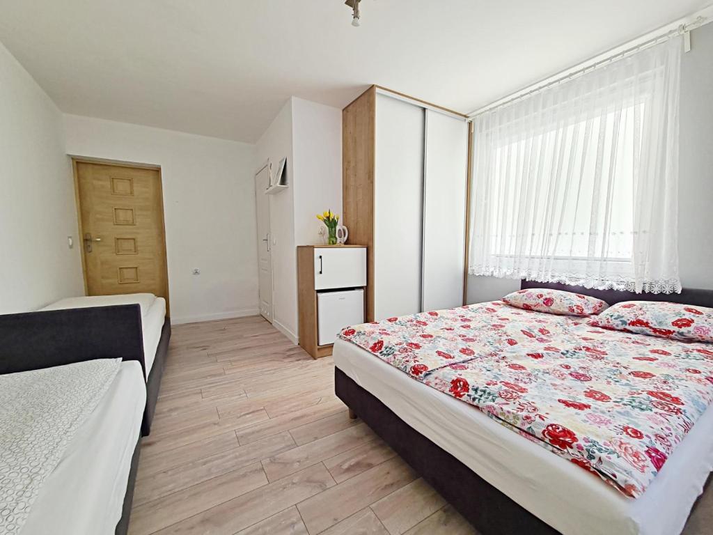 a bedroom with two beds and a window at Chatka Morska in Karwia