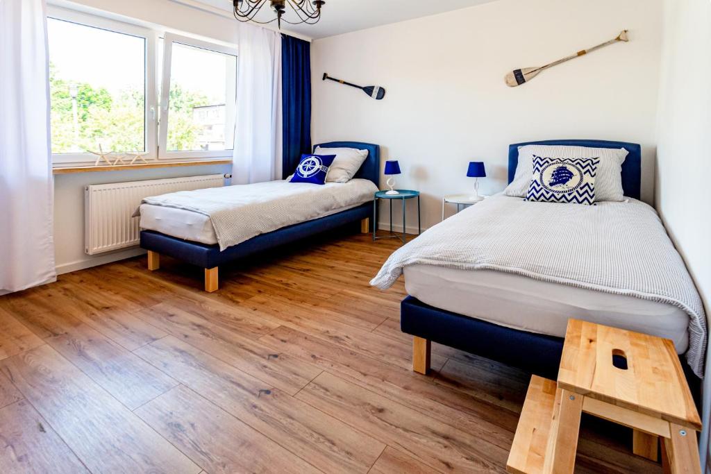 Un dormitorio con dos camas y una ventana. en Hostel &amp; Apartments Kołobrzeg, en Kołobrzeg