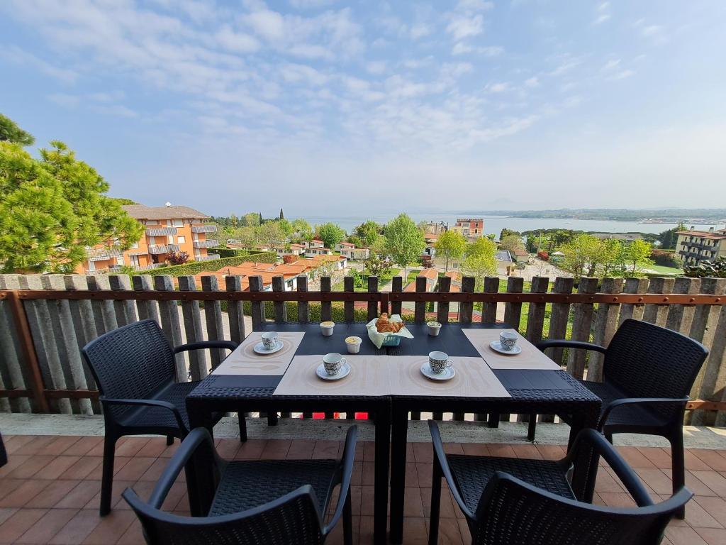 stół i krzesła na balkonie z widokiem w obiekcie Panorama Apartment Peschiera w mieście Peschiera del Garda