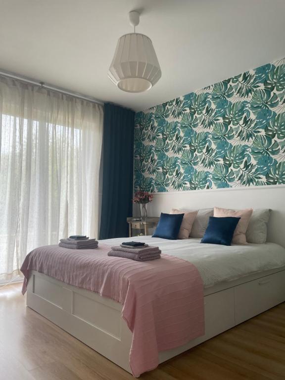 a bedroom with a large bed with blue and green wallpaper at Apartamenty Zaczarowany Ogród in Kazimierz Dolny