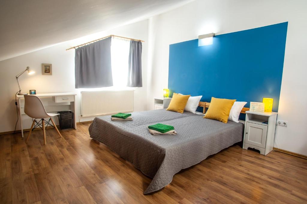 ein Schlafzimmer mit einem Bett und einer blauen Wand in der Unterkunft Cozy Room AGAPEDIA in Braşov