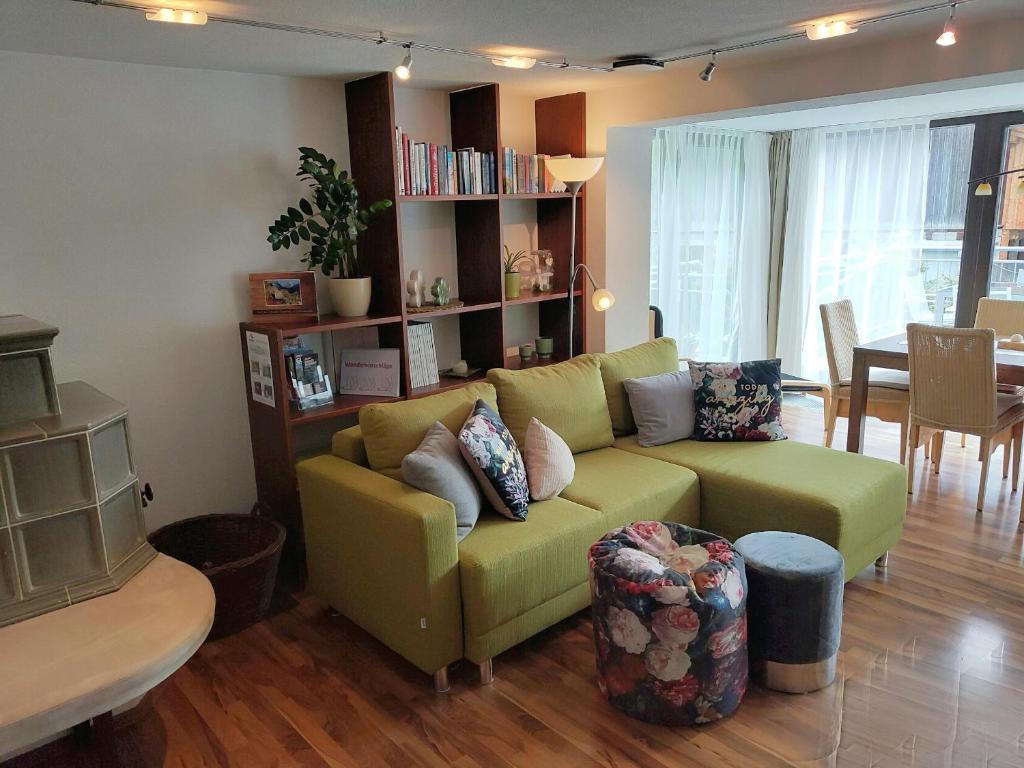 ein Wohnzimmer mit einem grünen Sofa und einem Tisch in der Unterkunft Ferienwohnung Alte Post in Sankt Leonhard im Pitztal