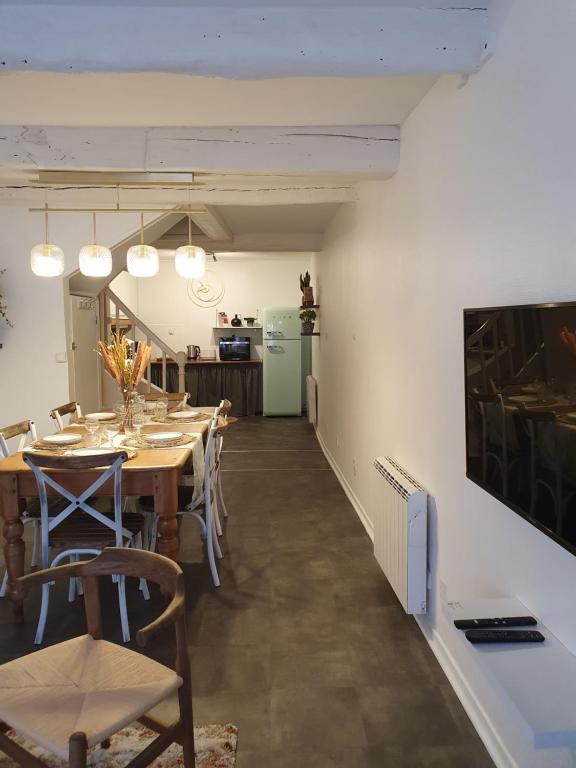 a dining room with a table and chairs and a kitchen at La Caponnière in Carcassonne