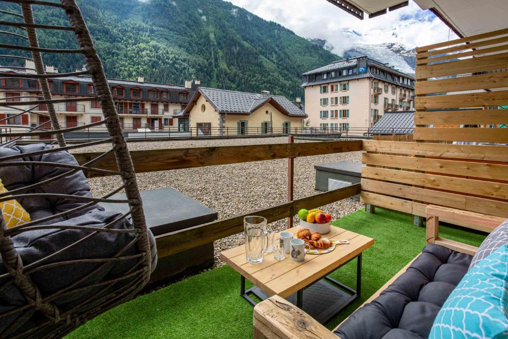 einen Balkon mit einem Tisch und Obst darauf in der Unterkunft Concordia 7 Apartment - Chamonix All Year in Chamonix-Mont-Blanc