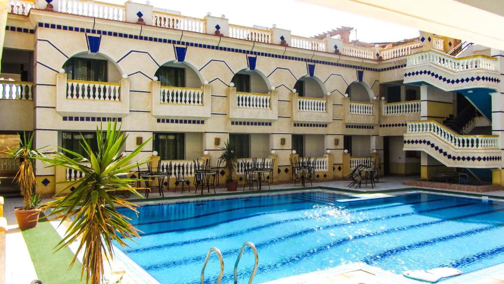 un hotel con piscina frente a un edificio en La Reine Dahab Hotel en Dahab