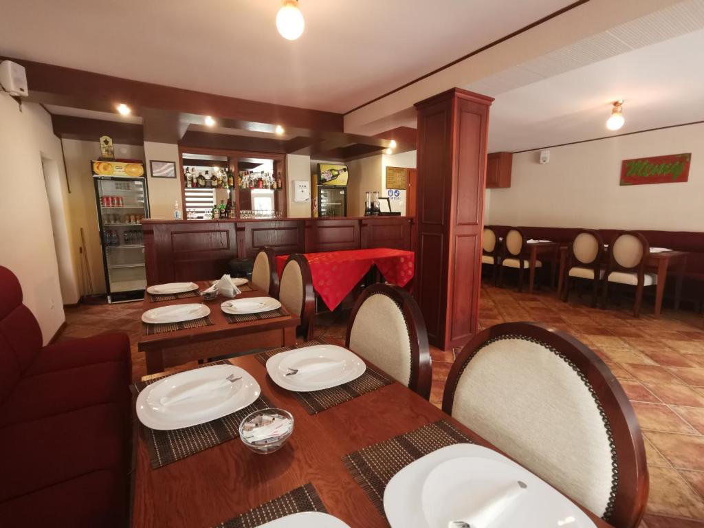 a dining room with a table and chairs in a restaurant at Pensiunea Memy in Buşteni