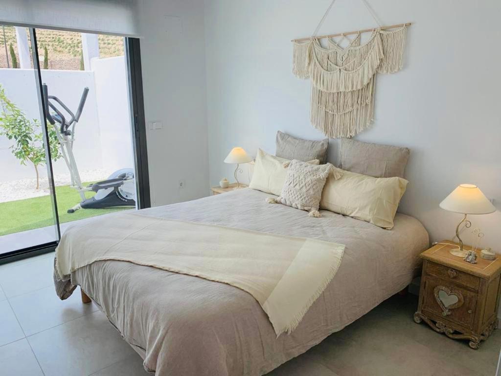 ein Schlafzimmer mit einem großen Bett und einem großen Fenster in der Unterkunft Villa Jasmin in Finestrat