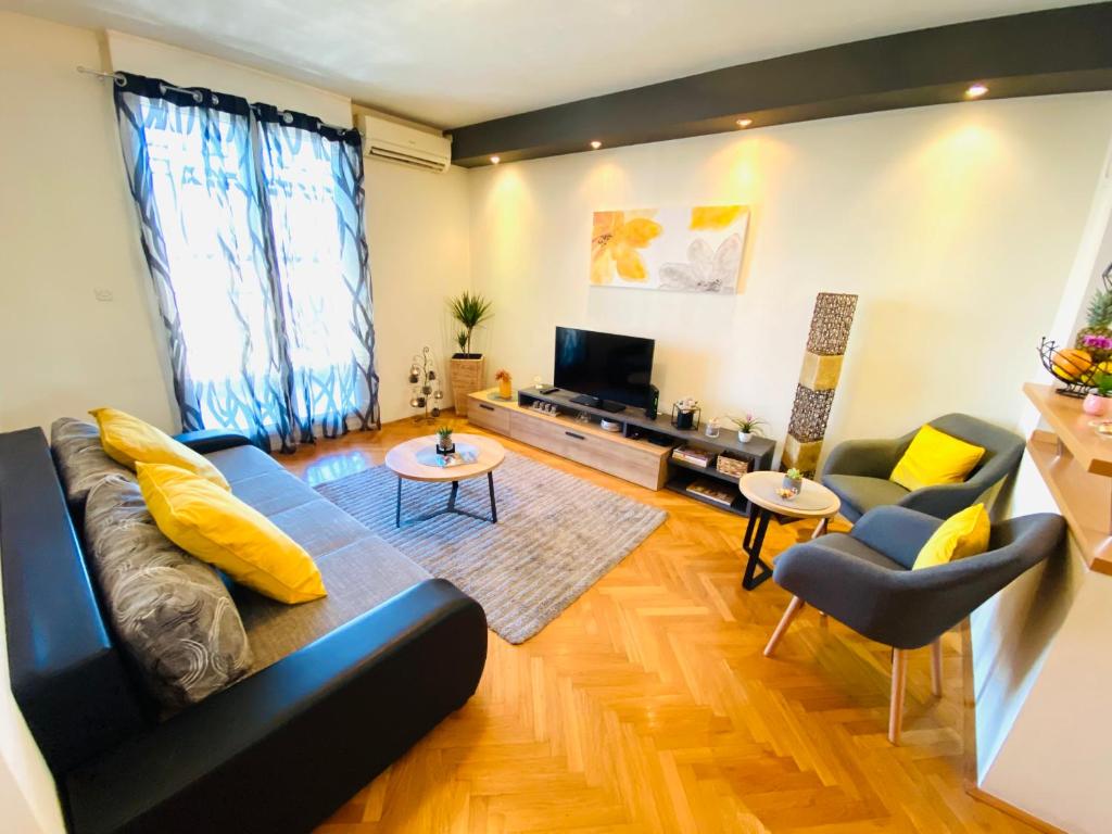a living room with a blue couch and yellow pillows at Apartment Lucija in Split