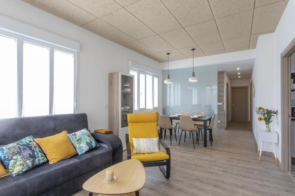 a living room with a couch and a dining room at Playa Ribeiría apartamento vacacional in Tapia de Casariego