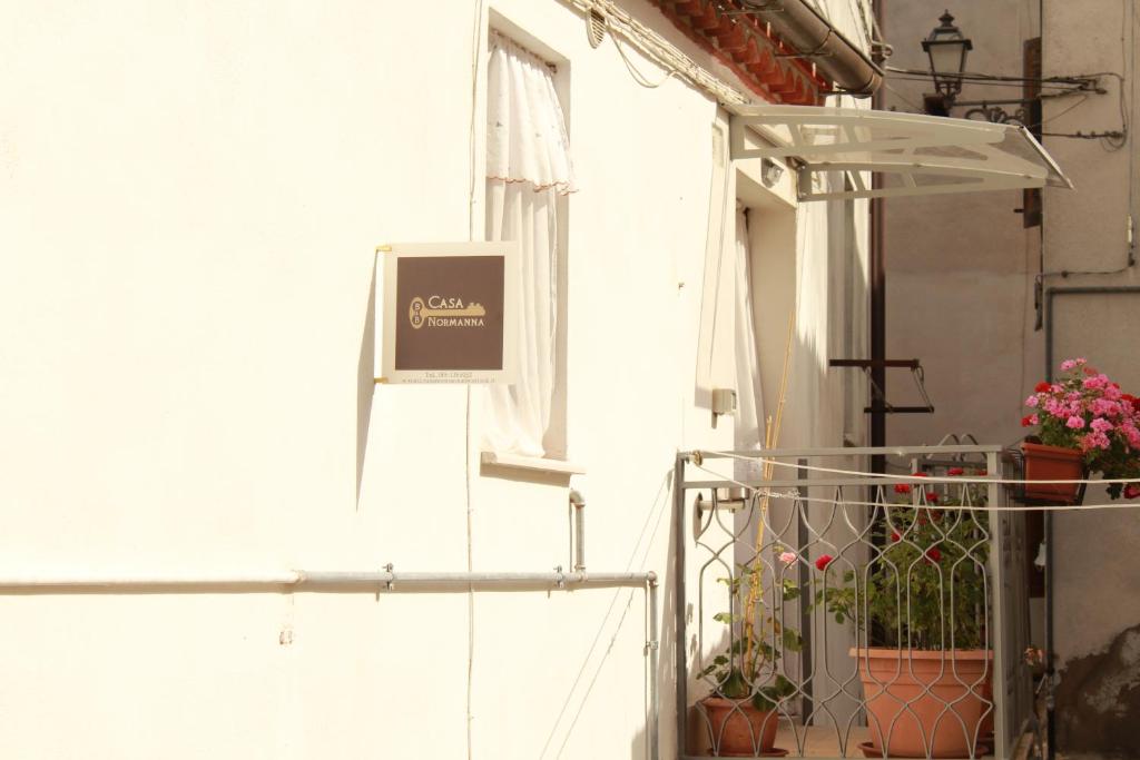 - un bâtiment blanc avec un balcon muni d'un panneau dans l'établissement Casa Normanna, à Acerenza