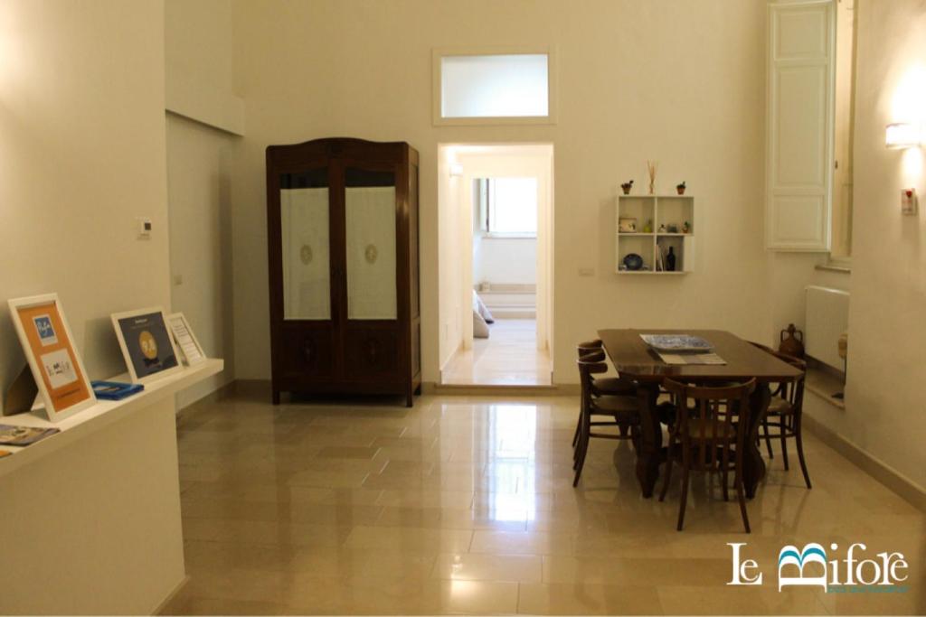 a kitchen and dining room with a table and chairs at Le Bifore B&B in Molfetta