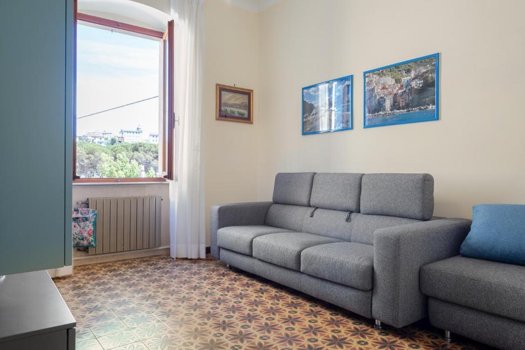 uma sala de estar com um sofá e uma janela em Cadimare Lovely Apartment em La Spezia