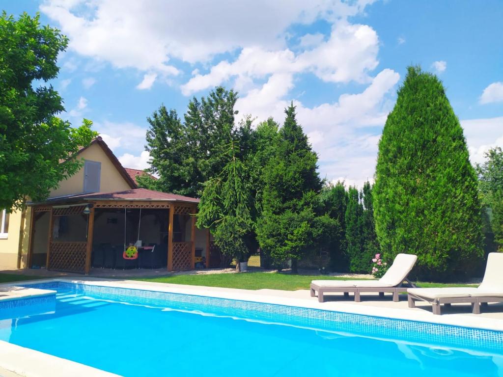 una piscina con 2 tumbonas y una casa en Garden & Pool apartment en Trnava