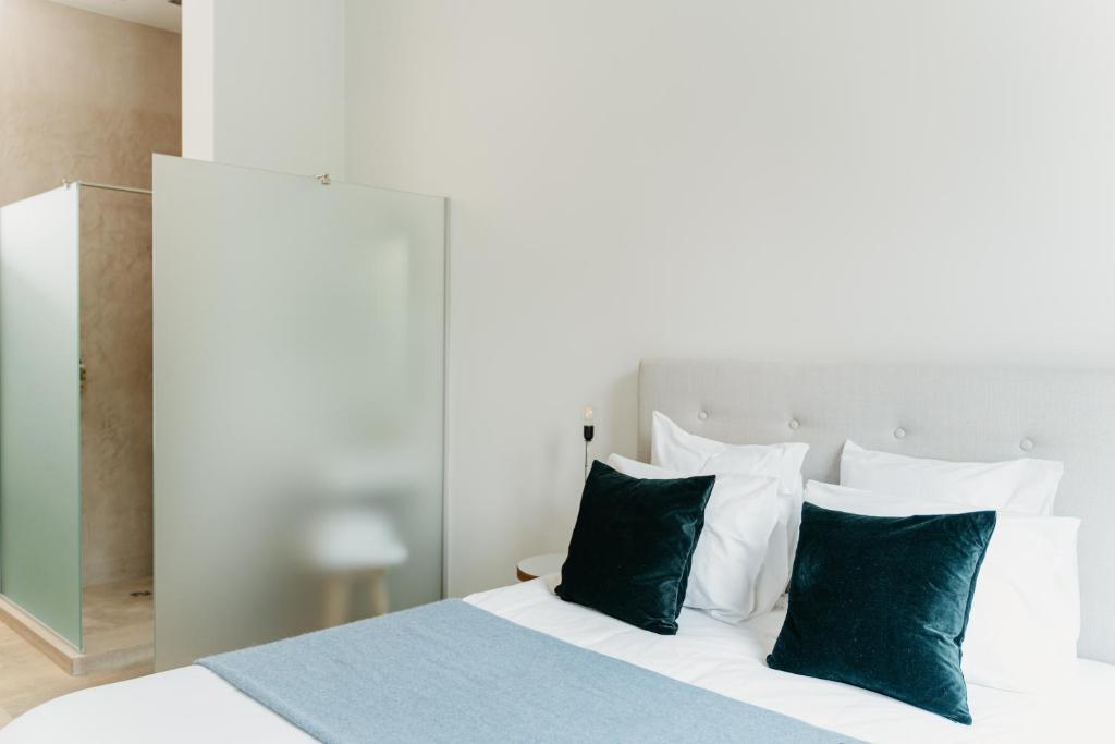 1 dormitorio con 1 cama con almohadas verdes y blancas en The 1880 Residence by Domani Hotels, en Amberes