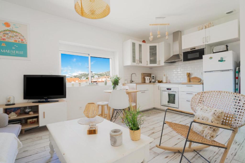 une cuisine et un salon avec une table et des chaises dans l'établissement Le Pitchoun, à Marseille