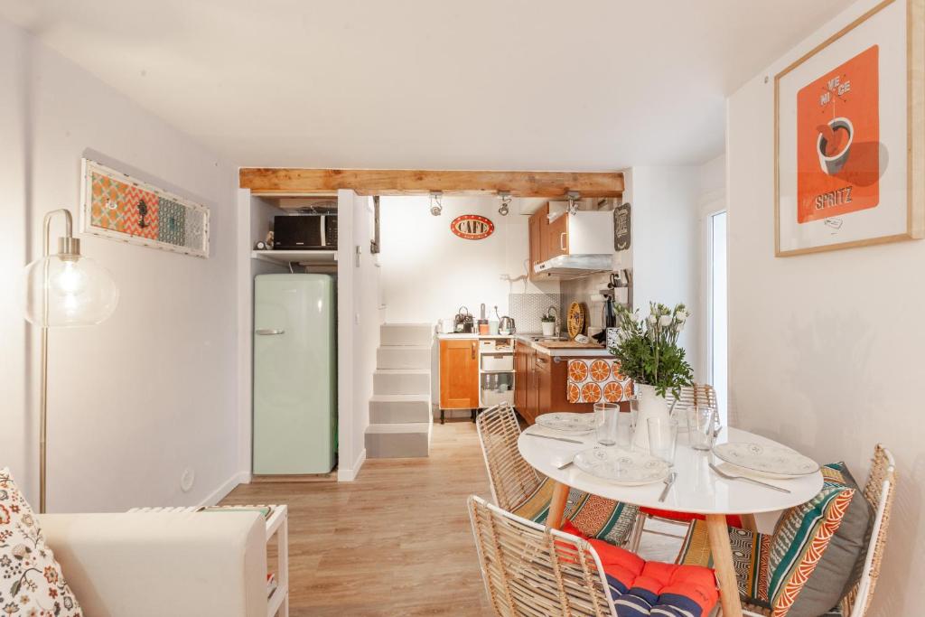 uma cozinha e sala de jantar com uma mesa branca e cadeiras em Le Cabanon du Vieux Port em Marselha