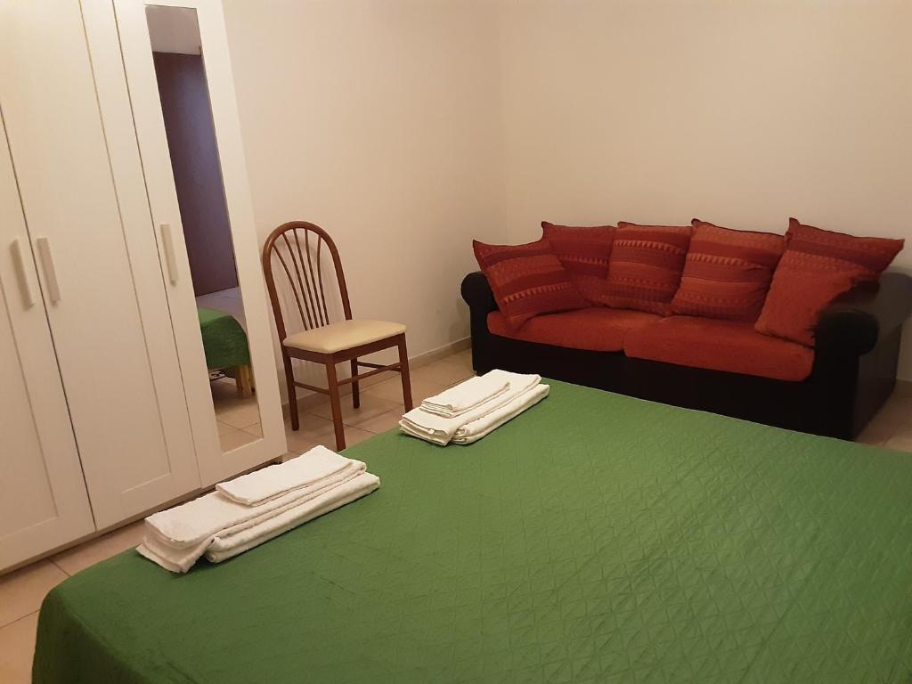 a living room with a green table with a couch at Locazione Menini - Camere zona stazione in Padova