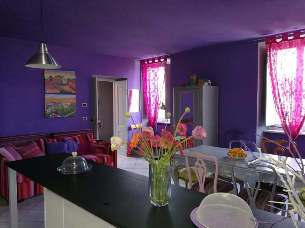 Fioletowa kuchnia z wazonem kwiatów na stole w obiekcie Casa Pressenda Apartment w mieście La Morra