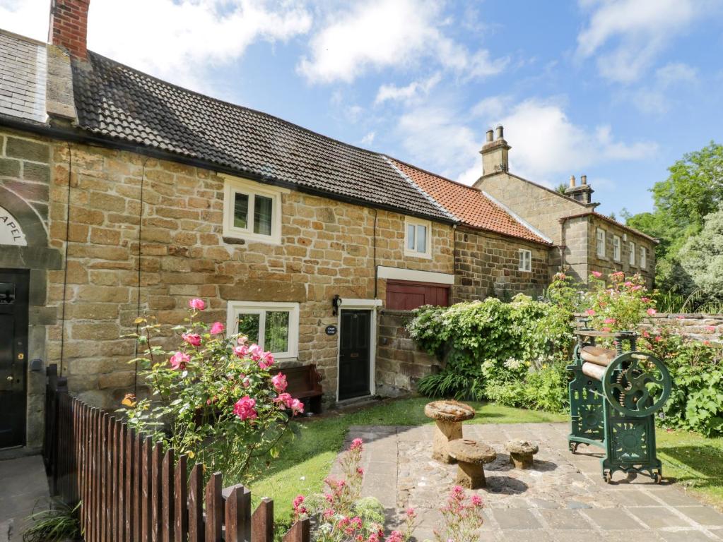 an old stone house with a garden in front of it at Chapel Cottage in Redcar
