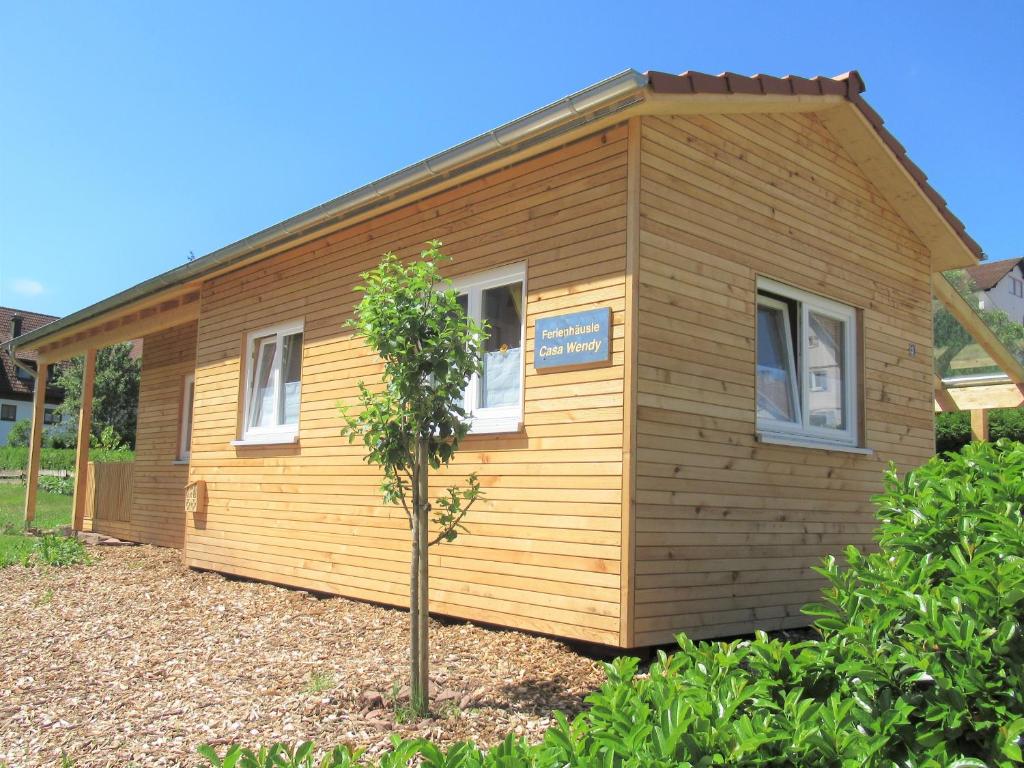ein kleines Holzhaus mit einem Baum davor in der Unterkunft Tiny-Ferienhäusle Casa Wendy in Loßburg