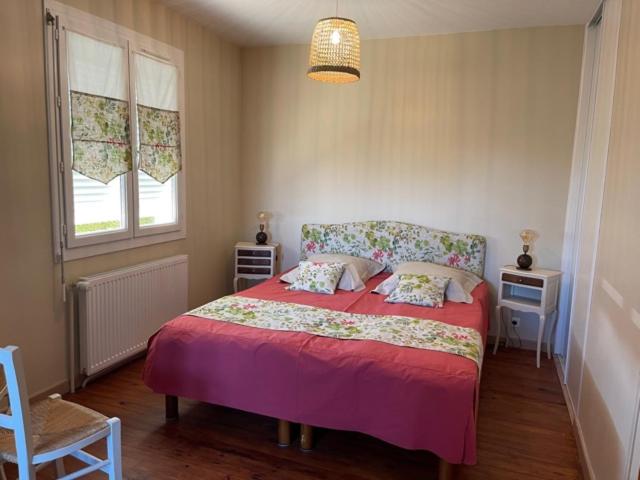 a bedroom with a bed and a chair and a window at Le chasse marée in Offranville