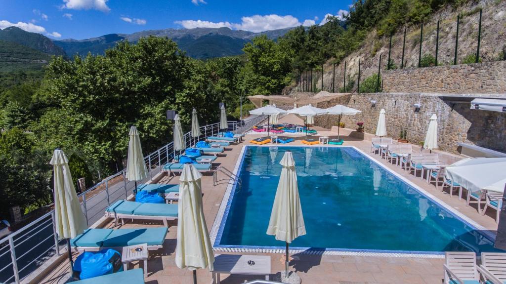 una piscina in un hotel con sedie e ombrelloni di Nymfes Hotel a Kato Loutraki