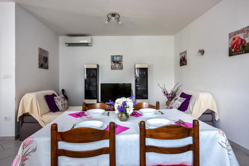 a dining room with a table with flowers on it at Apartman Koraca in Roč