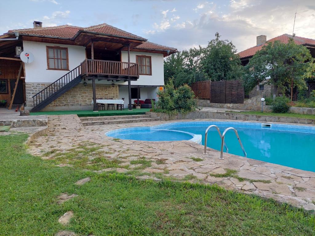 een huis met een zwembad voor een huis bij СЪНТОВЕЦ - къща за гости in Asparuchovo