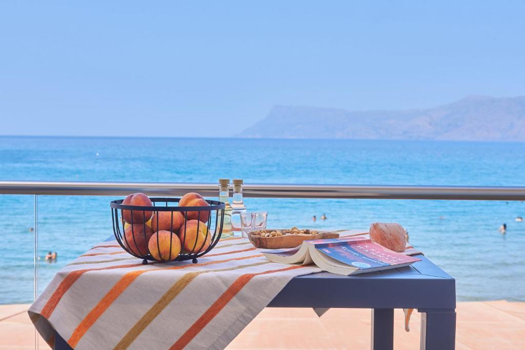 a table with a bowl of fruit on a table with the ocean at Seaside House in Kissamos