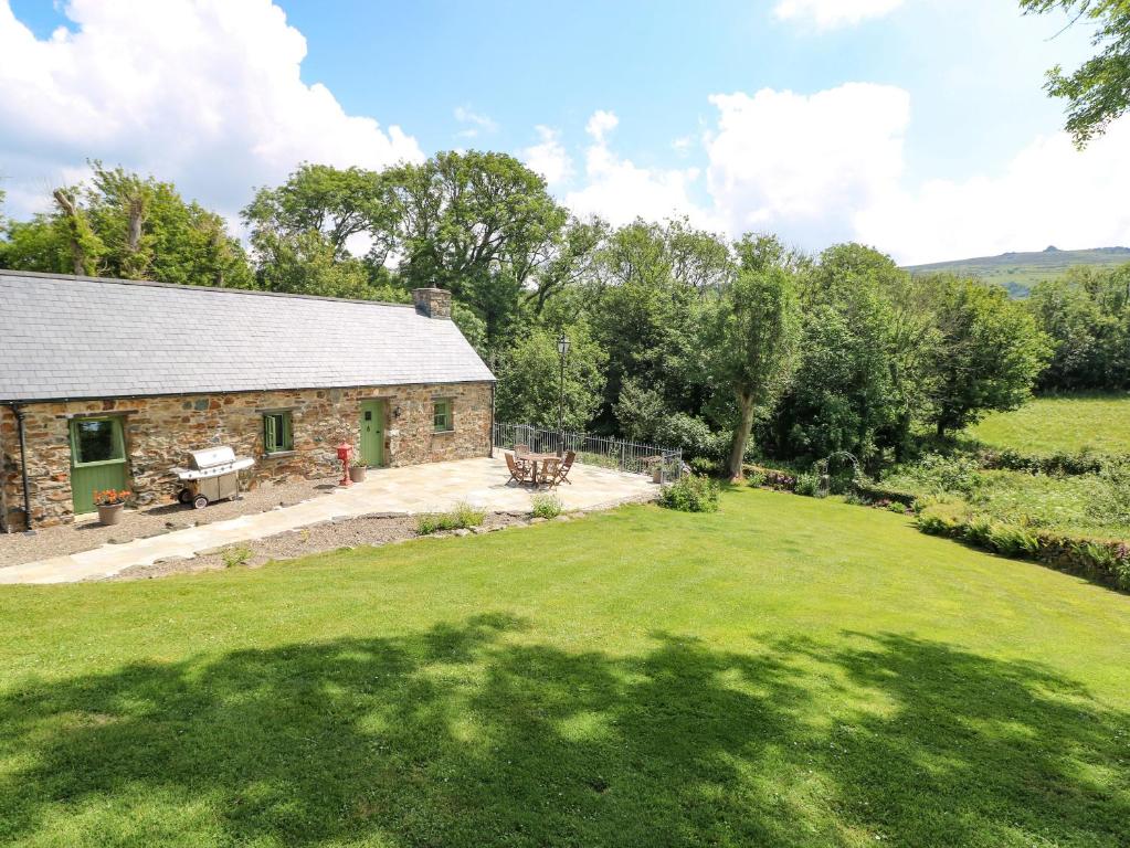 a stone cottage with a large grass yard at Trewrach Cottage in Newport