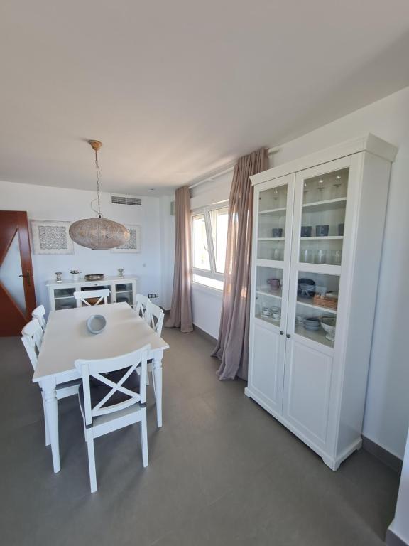 a white dining room with a white table and chairs at Moraira Beach in Moraira