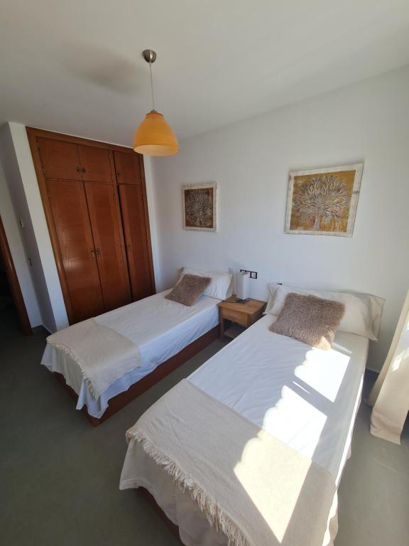 a bedroom with two beds and a table and a lamp at Moraira Beach in Moraira