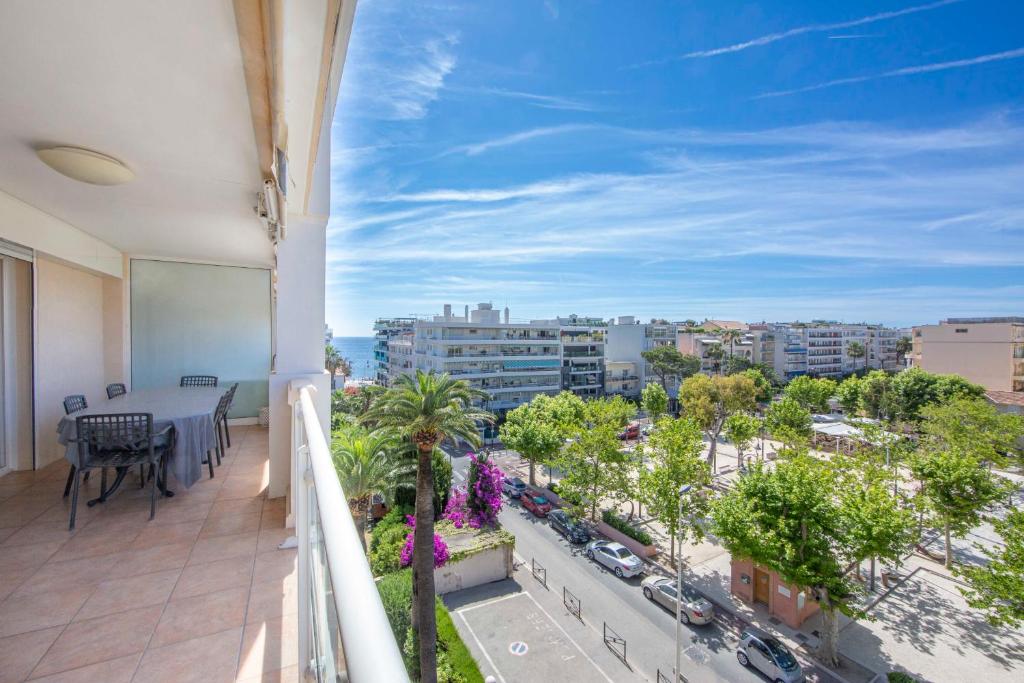 einen Balkon mit einem Tisch und Stadtblick in der Unterkunft Apartment 2 bedrooms 2 bathrooms clear view in Palm beach area in Cannes