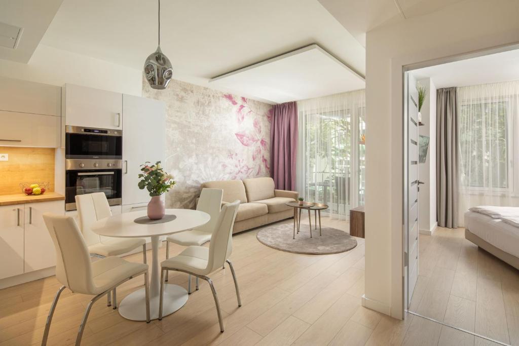 Il comprend une cuisine et un salon avec une table et des chaises. dans l'établissement Spa Residence Carbona Hévíz - Relax, Sissi Apartmanok, à Hévíz