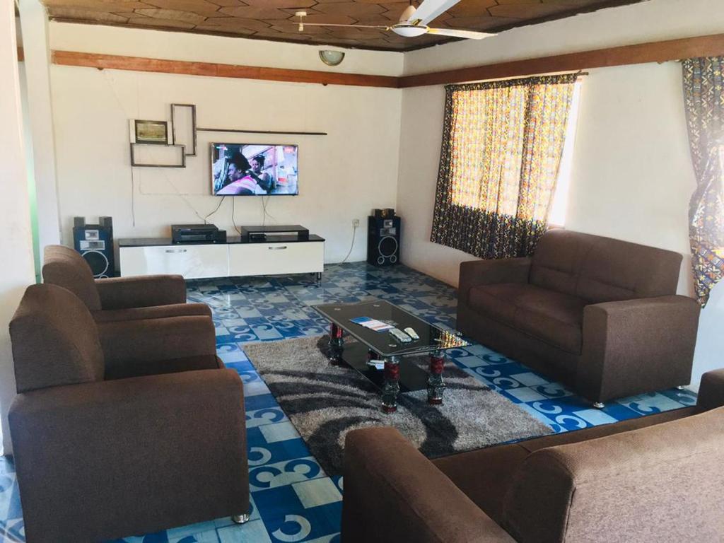 a living room with two couches and a tv at Feel At Home & be close to the Labadi Beach (5min) in Accra