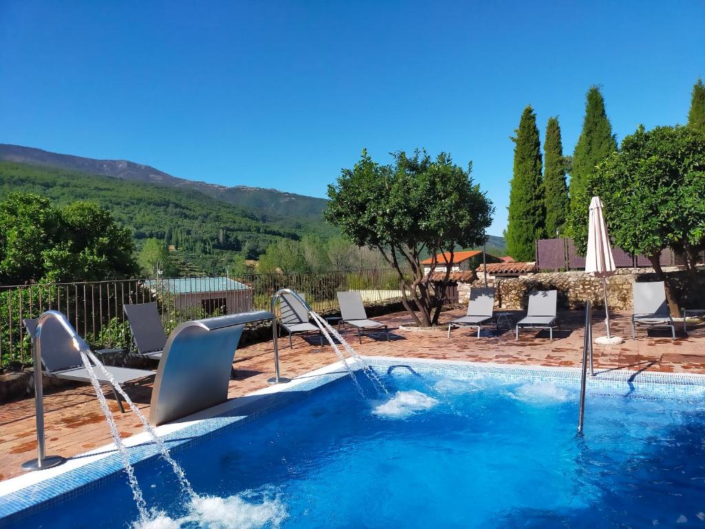 a swimming pool with a water fountain in a yard at Aura del Jerte in Jerte