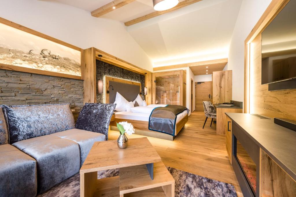 ein Hotelzimmer mit einem Bett und einem Sofa in der Unterkunft Wohlfühlhotel Berg Heil in Holzgau