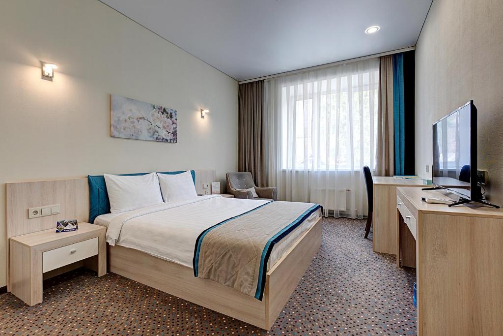 Habitación de hotel con cama y TV de pantalla plana. en Hotel Berg Haus, en Tver