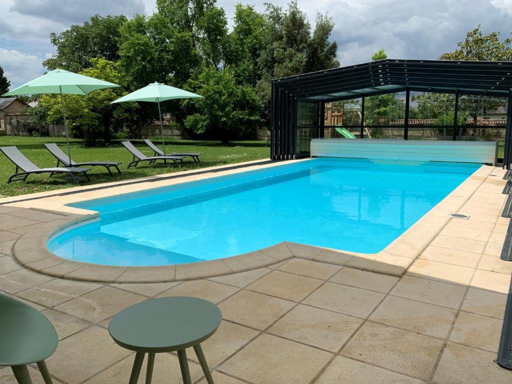 a swimming pool with chairs and umbrellas at Château l&#39;Hubertière, classé du tourisme 4 étoiles in Bouresse