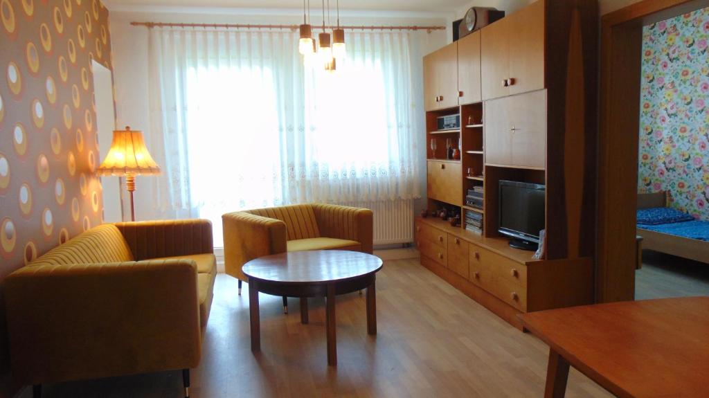 sala de estar con mesa, sillas y TV en Ferienwohnung Ernst 10 en Gelenau