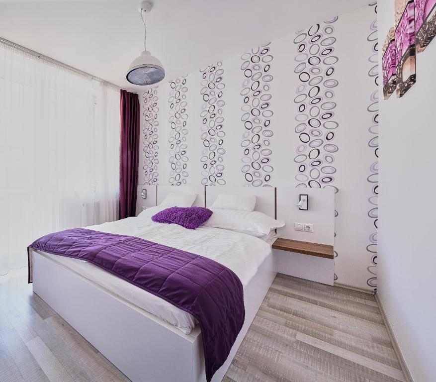 シャールヴァールにあるApartman Rubinのベッドルーム(紫の毛布付きのベッド1台付)