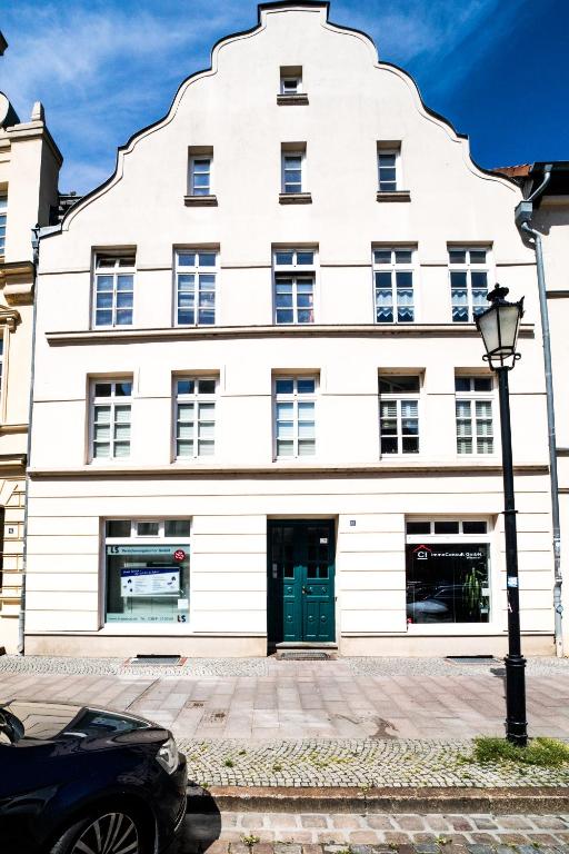 a white building with a green door at Wismarer Heckflosse in Wismar