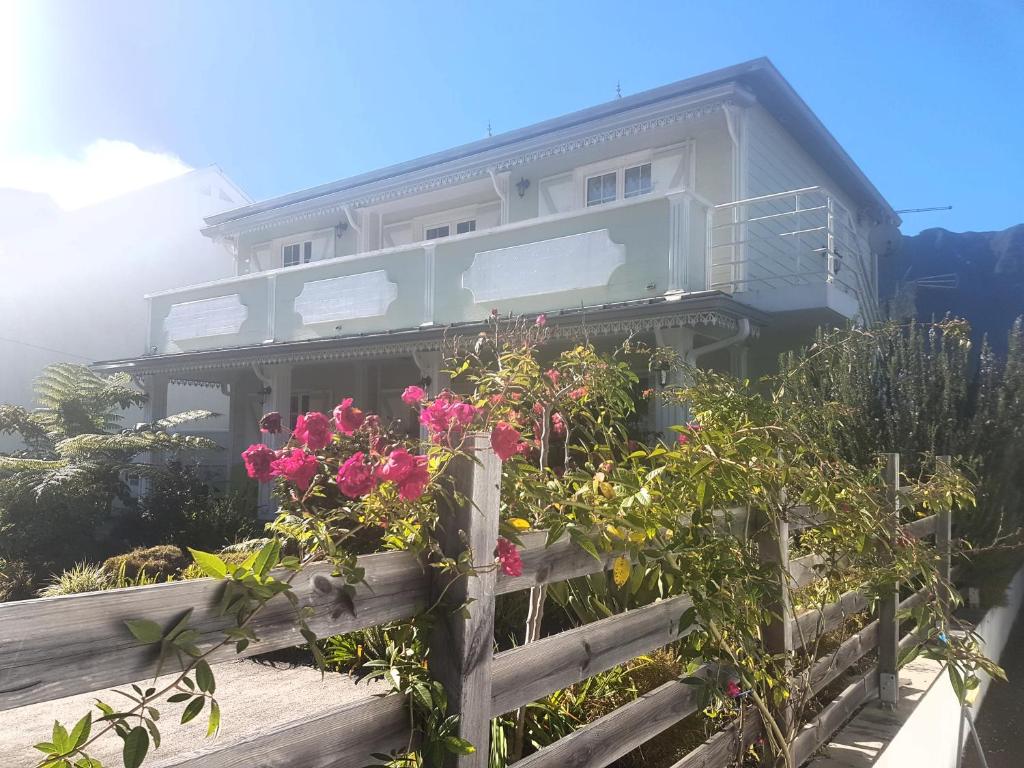 a house with pink flowers on a fence at La Belle Créole in Cilaos