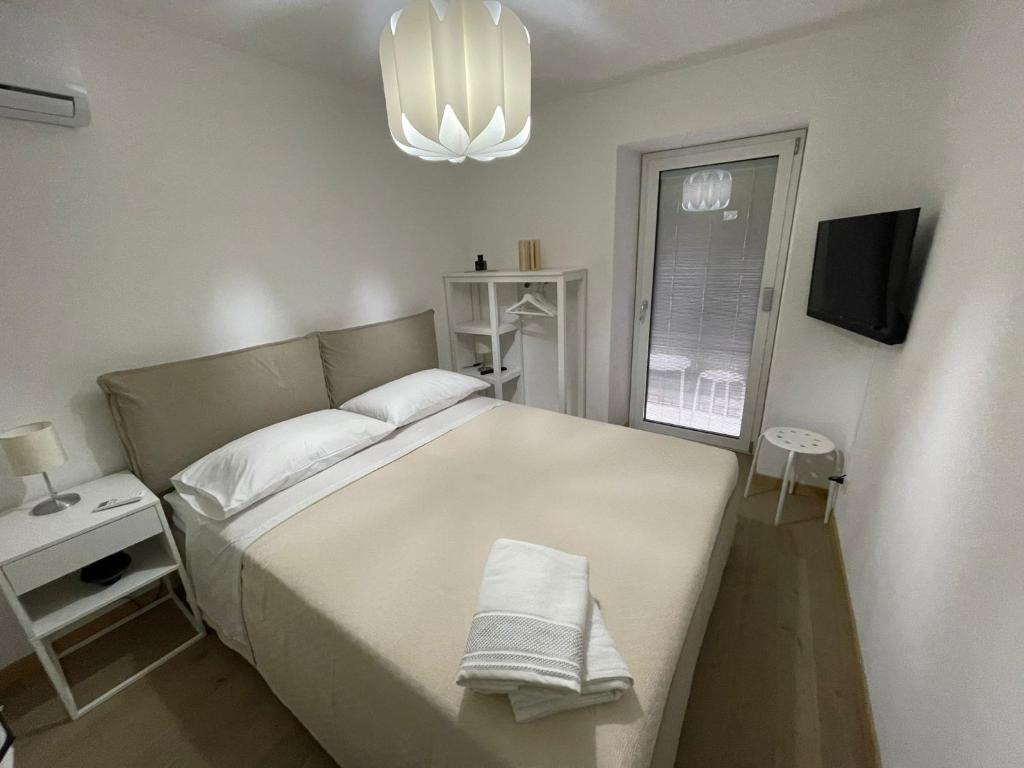 a bedroom with a large white bed and a chandelier at Ale e Franz in Cefalù