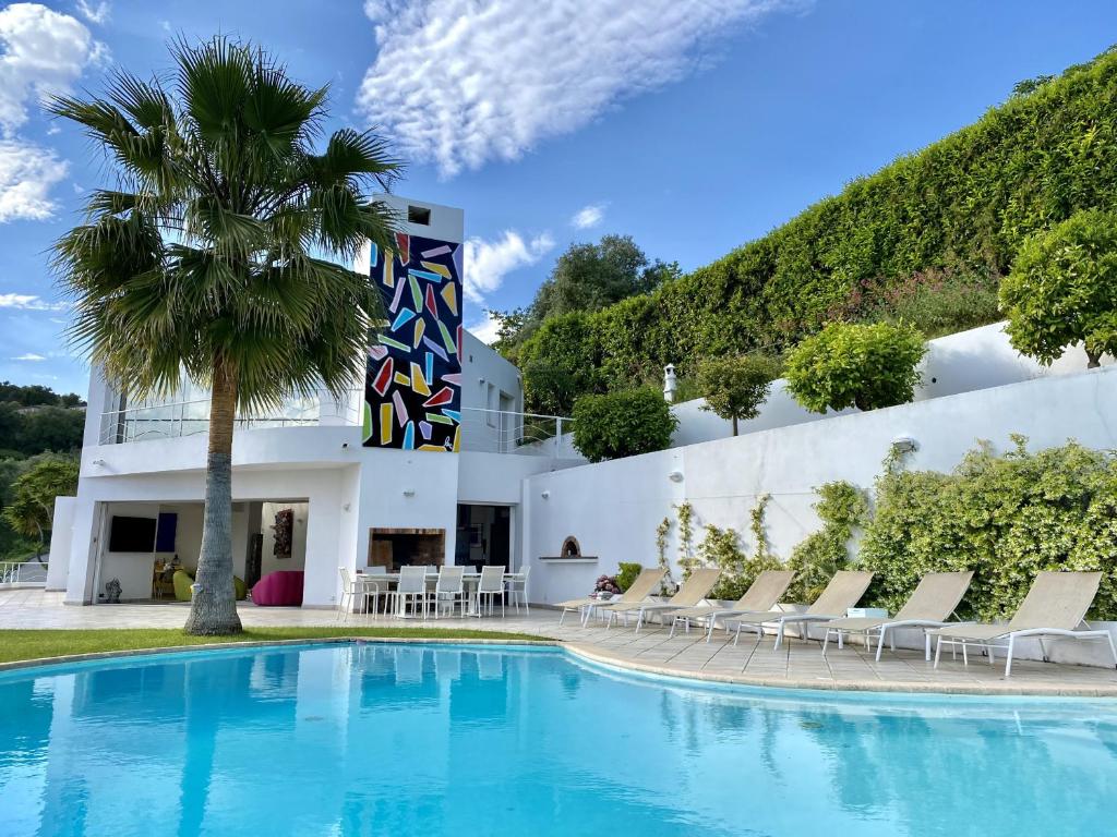 un hôtel avec une piscine et des chaises et un bâtiment dans l'établissement VILLA NICE-GAIRAUT by RIVIERA HOLIDAY HOMES, à Nice